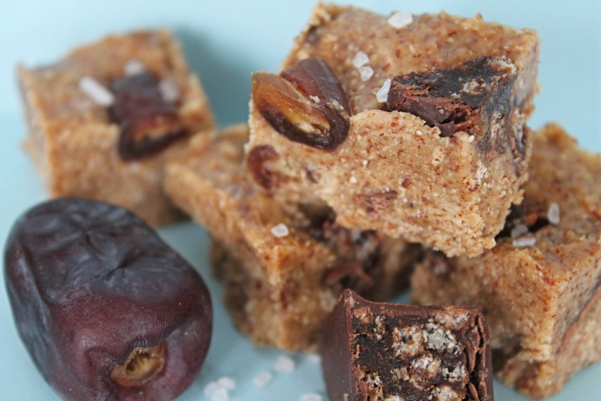 cubes of home made salted toffee nut butter fudge with pieces of chocolate and dates