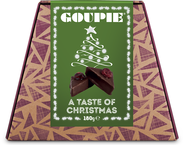 A box of Taste of Christmas Goupie featuring a kraft and purple triangular pattern and a green label with a stylised Christmas tree and two pieces of Taste of Christmas Goupie. Red cranberries top the chocolate coated triangle pieces.