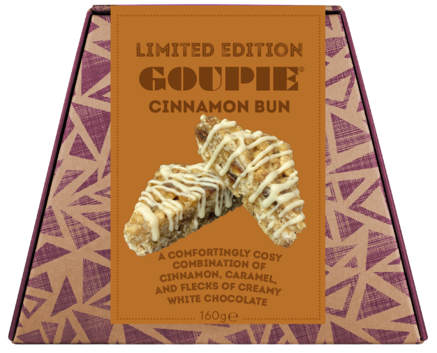 A boxed gourmet chocolate bun from Goupie, featuring a tan and purple geometric patterned box with a central label showing a cinnamon bun drizzled with white chocolate.
