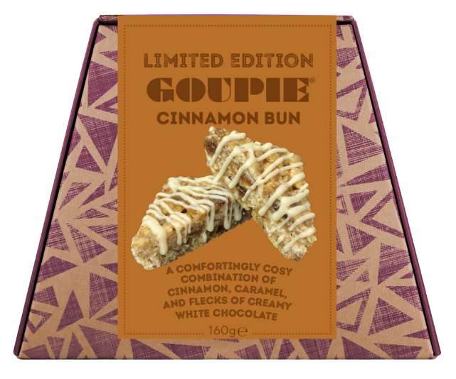 A boxed gourmet chocolate bun from Goupie, featuring a tan and purple geometric patterned box with a central label showing a cinnamon bun drizzled with white chocolate.