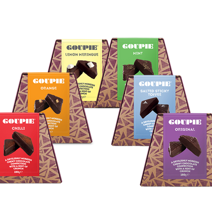 Set of vegan chocolate boxes in various flavours with colourful packaging arranged in a rainbow