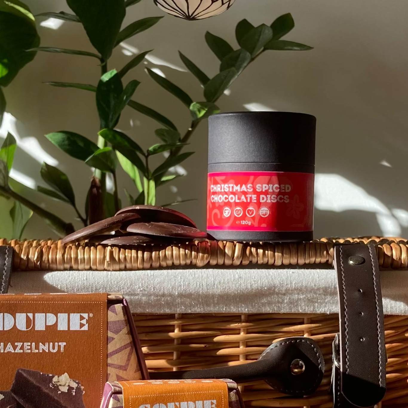 Christmas spiced vegan chocolate discs in black cardboard tube