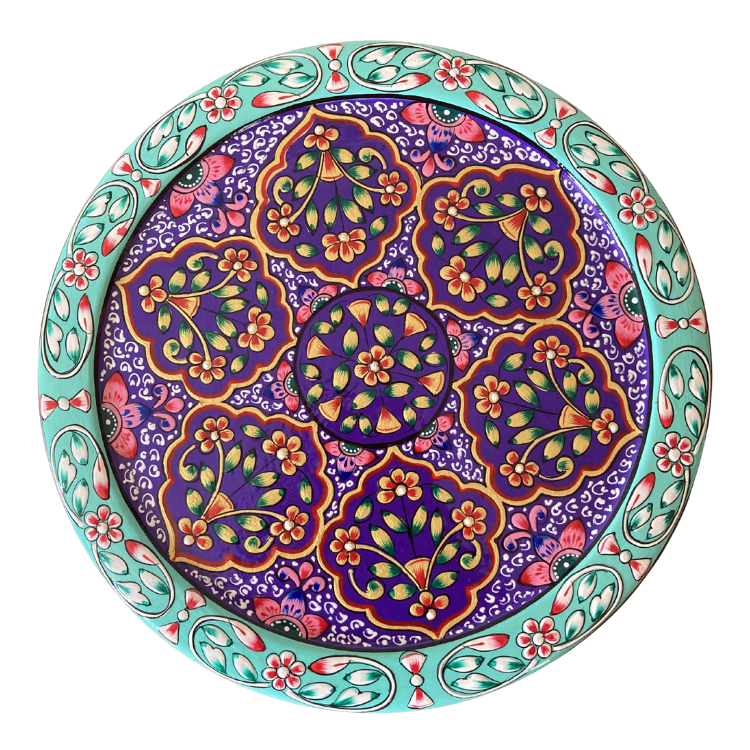 A round decorative gift tin with a colourful floral and paisley pattern