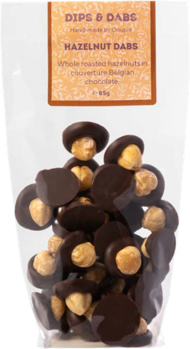 a home compostable bag of mini vegan chocolate discs, each topped with a whole hazelnut